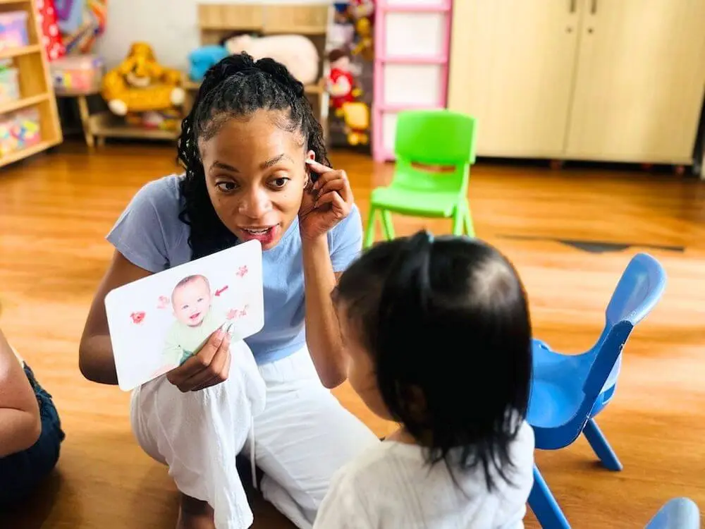 Volunteer supporting a child with a visual learning activity in Valencia, showing the childcare and education focus of Abroad Escape volunteer programs in Spain.