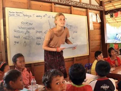Volunteer teaching English to children at a school in rural Cambodia